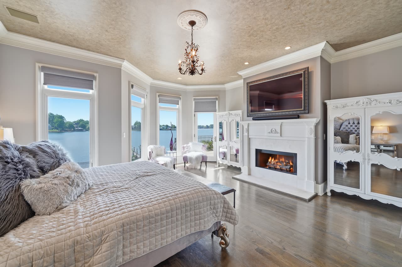Primary bedroom, fireplace lit, water beyond